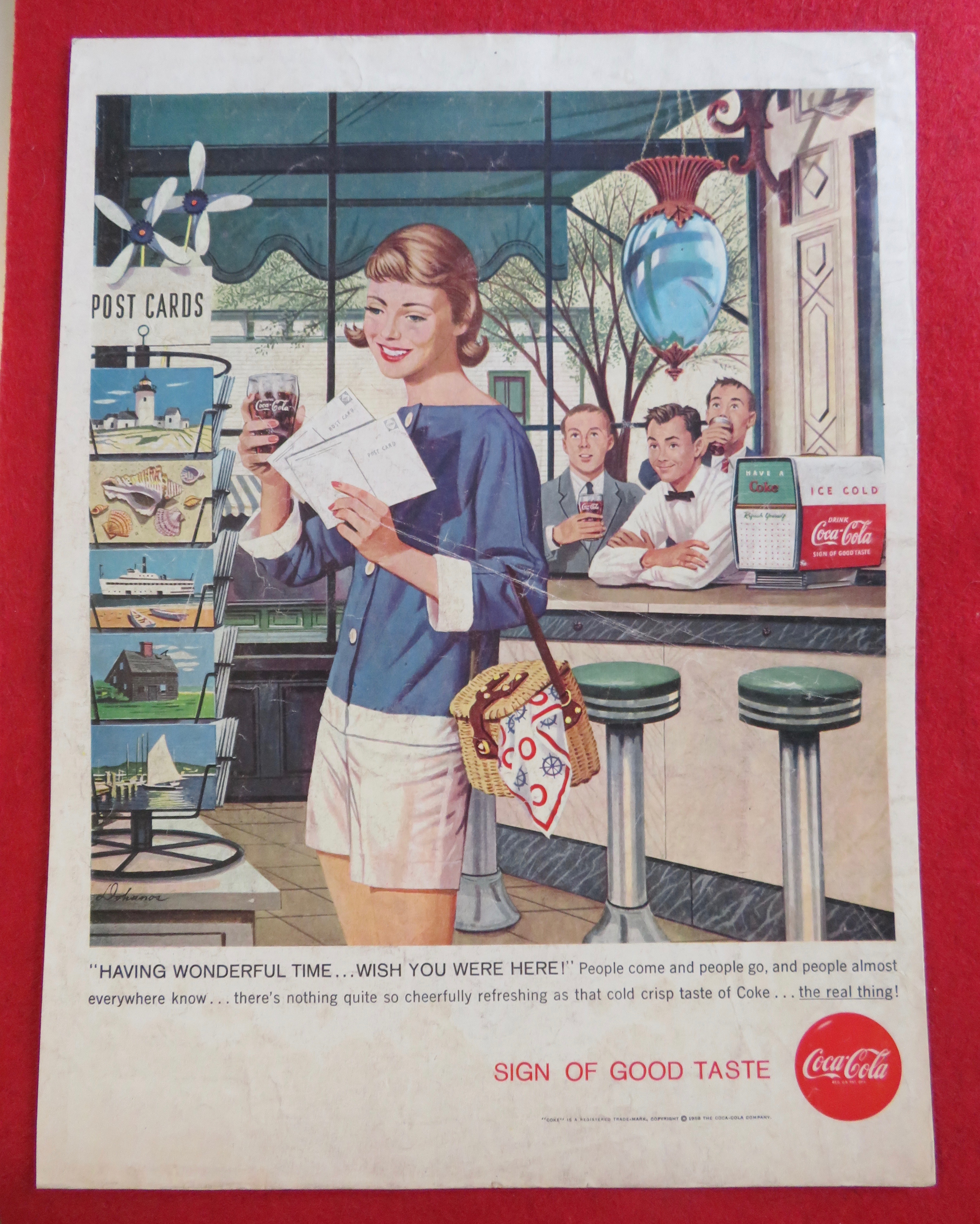 1958 Coca Cola (Coke) with Girl Looking at Postcards