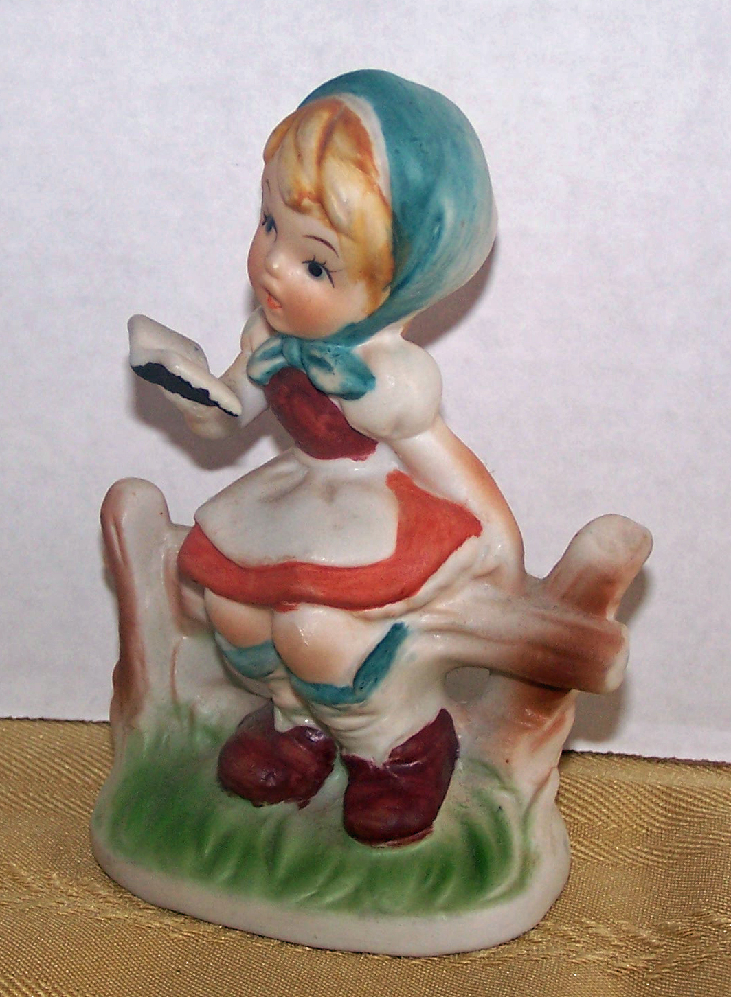 Bisque Girl Sitting on Fence, Holding a Book