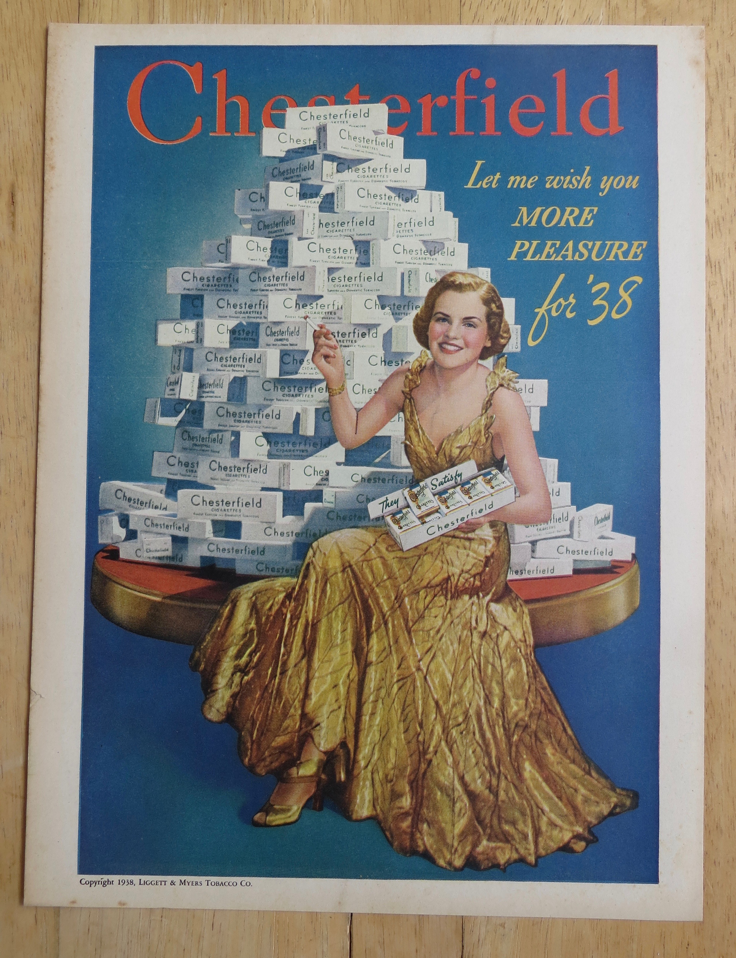 1938 Chesterfield  Cigarettes w/Woman Sitting By Stack