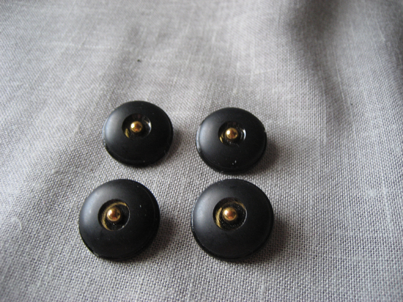 Four Black and Metal Buttns
