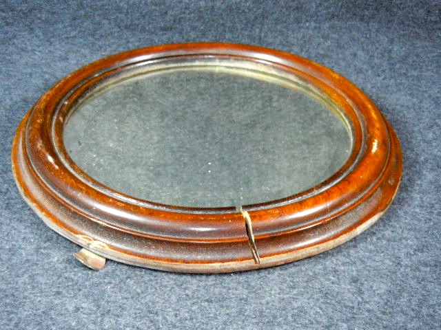 Beveled glass mirror in round wood frame