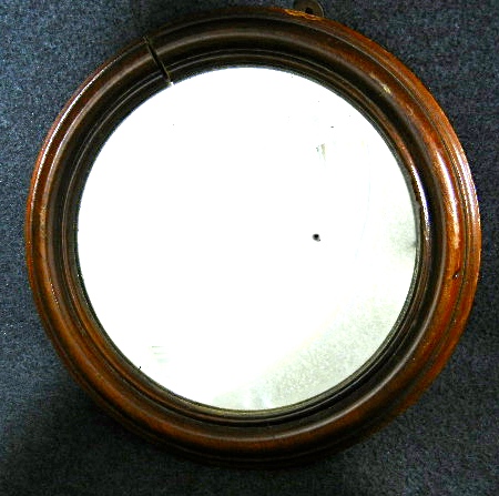 Beveled glass mirror in round wood frame