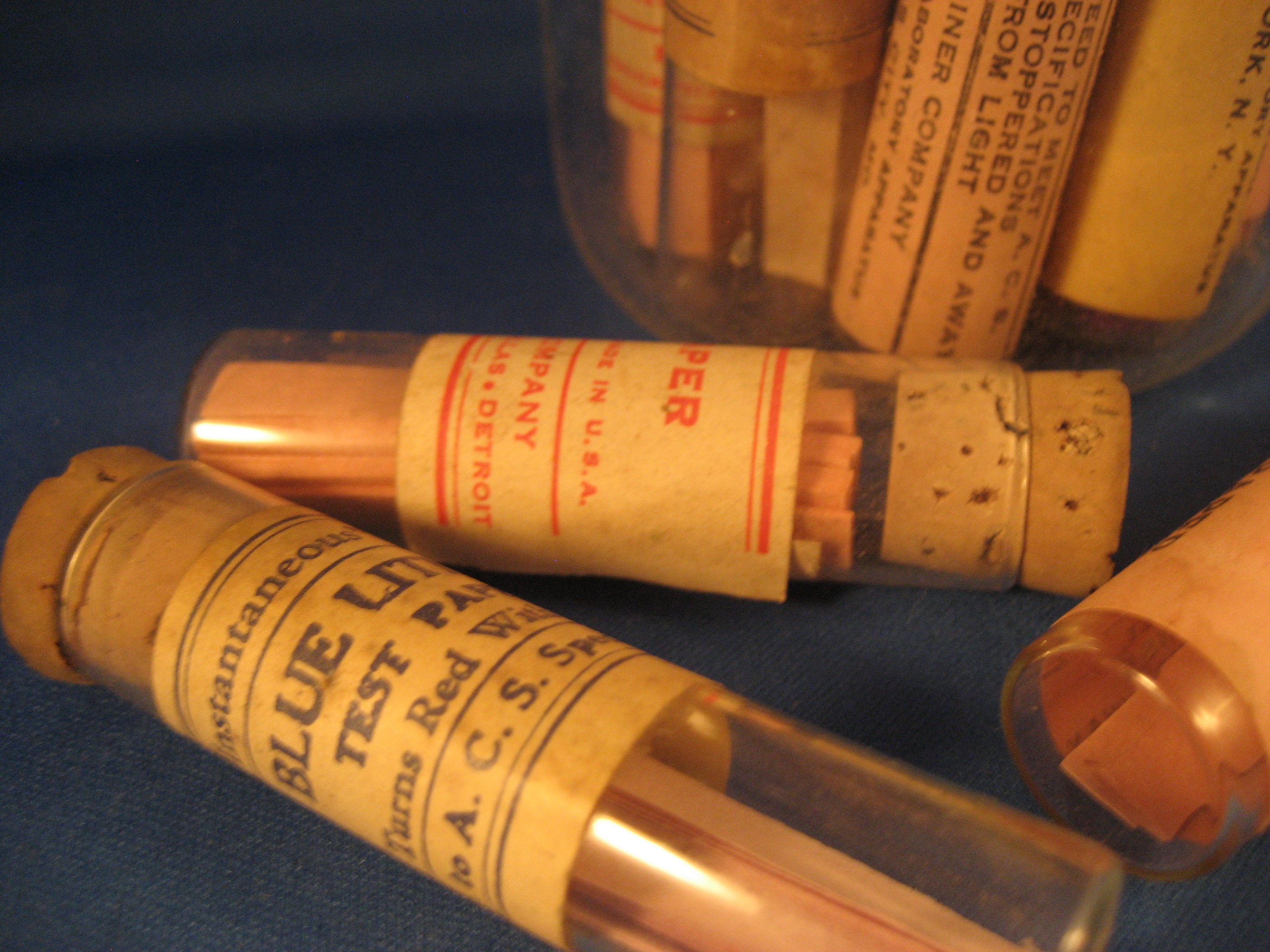 Thirteen Glass Tubes of Litmus Paper and Beaker